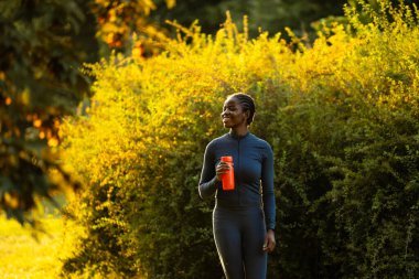 Gün batımında koşan motive kadın sporcu.