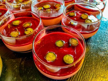 Sütlü panna cotta, çilekli veya ahududu soslu. Hassas İtalyan tatlıları, doğal jöle ile kaplanmış, üzümlerin yarısıyla süslenmiş. Bir şenlik, parti ya da düğün organizasyonunda