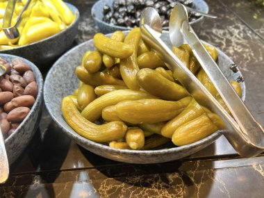 Turşu tabağı, gri bir arka planda salatalık turşusu. Temiz yemek, vejetaryen yemek konsepti. Metin için boşluk olan üst görünüm