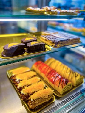 Şekerci tezgahında, keklerle. Pastane vitrininde kremalı veya meyveli pasta seçeneği