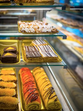 Şekerci tezgahında, keklerle. Pastane vitrininde kremalı veya meyveli pasta seçeneği