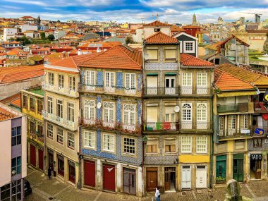 Portekiz 'in Porto şehrinin çatılarının manzarası. Döşemeli çatılar gökyüzüne karşı ışıldıyor.