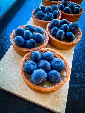 cakes for buffet table-small baskets with custard, decorated with blueberries.Petit fours help out at receptions, banquets,and numerous feasts.at catering event on some festive event,party or wedding