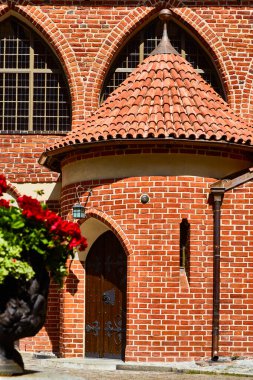 Olsztyn, Poland, August 10, 2022. Entrance to Warmian Chapter Castle from courtyard. Construction of castle began in 1348, and 30-meter round tower with southern wing was added in 15th century.