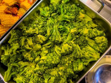 Baking tray filled with roasted chopped broccoli florets