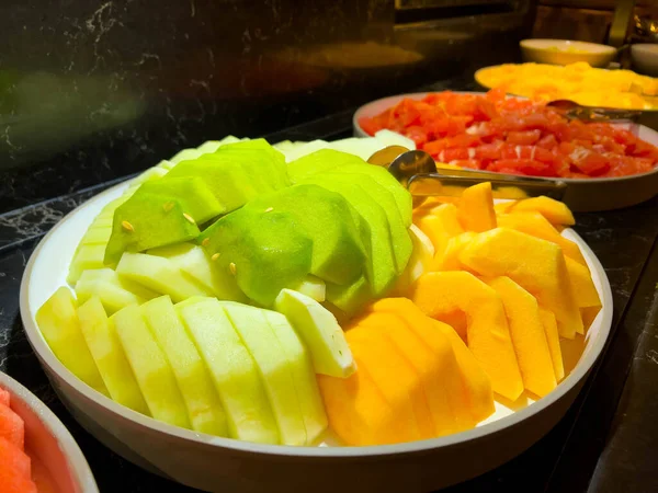 Plasterki Melona Różnych Kolorach Okrągłym Talerzu Zielony Żółty Pomarańczowy — Zdjęcie stockowe