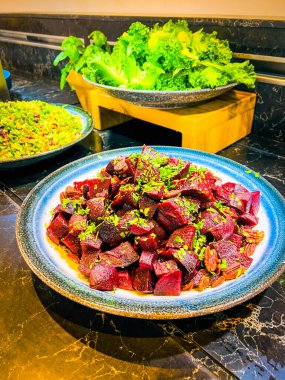 Büyük parça haşlanmış pancar salatası, yeşil soğan, badem. Çiğ pancar dilimleriyle süslenmiş. Bir şenlik organizasyonunda, bir partide ya da düğünde. Açık büfe