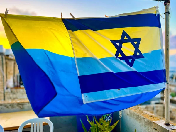 通りでは 2つの旗 ウクライナの大きな旗とイスラエルの小さな旗 風になびく — ストック写真