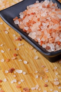 Tahta masadaki bir kase Himalaya Pembe Tuzu 'nu kapat.