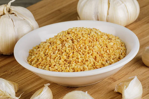 A close up of the spice Minced Garlic isolated on a wooden background with copy space