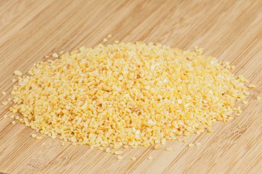 Tahta bir kesme tahtasına izole edilmiş, kopyalanmış sarımsak yığını.