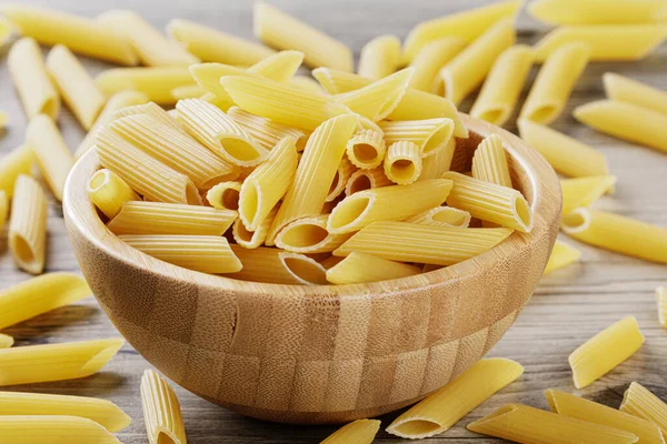 Raw Penne Rigate Noodles Isolated Gray Wooden Background — Stock Photo, Image