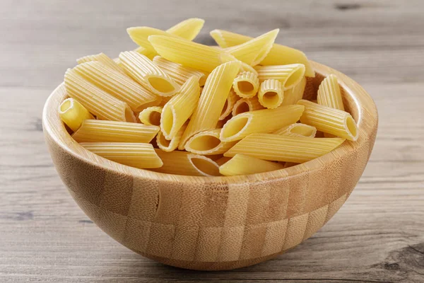 Raw Penne Rigate Noodles Isolated Gray Wooden Background — Stock Photo, Image