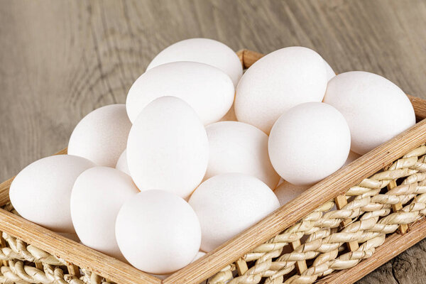 Close up of  a basket of fresh raw White Eggs with  copy space