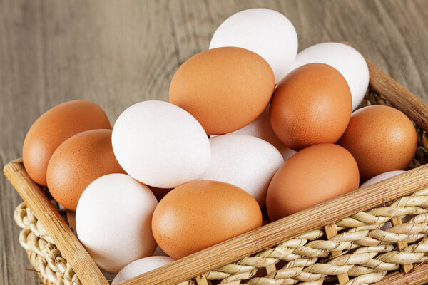 Close up of  a basket of fresh raw White and Brown Eggs with  copy space