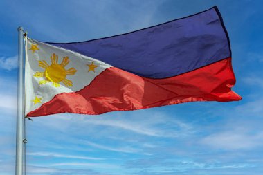 Filipin Bayrağı, rüzgarlı bir günde, Manila, Filipinler 'de mavi bir gökyüzünü izole etti.