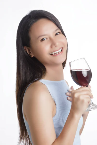 美しいアジアの女性は笑顔とコピースペースと白い背景に隔離された赤ワインのガラスを保持します — ストック写真