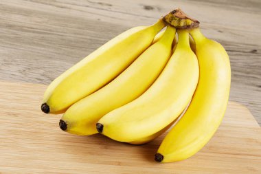 Ahşap bir arka planda izole edilmiş bir avuç lezzetli olgun muza yakın çekim