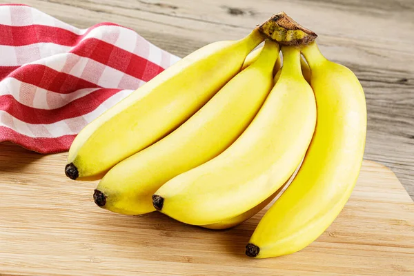 Großaufnahme Eines Bündels Leckerer Reifer Bananen Isoliert Auf Einem Holzhintergrund — Stockfoto