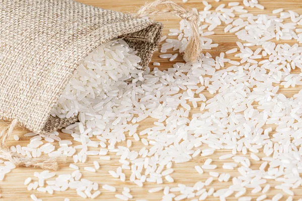 Ein Säckchen Weißer Reis Verschüttet Sich Auf Einem Hölzernen Schneidebrett — Stockfoto
