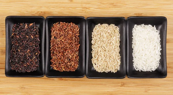 Dört Farklı Pirinç Siyah Kırmızı Kahverengi Beyaz Düz Bir Zemin — Stok fotoğraf