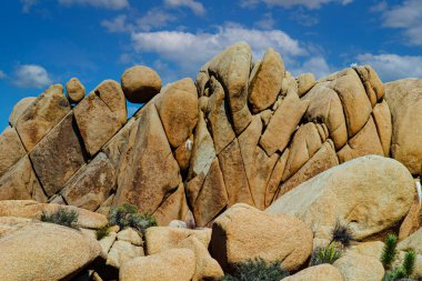 Joshua Tree Ulusal Parkı, Kaliforniya 'da granit kaya oluşumları. Kaya yığını, Dünya 'nın çekirdeğinden yükselen dikey kolonları gösteriyor. Yağmur, sel ve rüzgar kaynaklı kum sütunları aşındırarak burada görülen kaya yığınlarını oluşturdu..