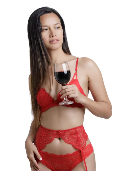 年轻的亚洲女人穿着红色内衣裤 手里拿着一杯红酒 背景是白色的 有复制的空间 — 图库照片