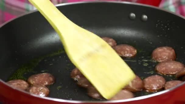 キッチンの赤いフライパンのソーセージのクローズアップ — ストック動画
