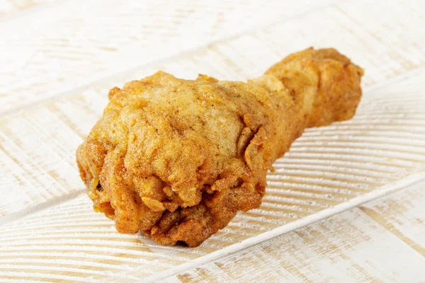 Close up of Fried Chicken Leg or Drumstick on a wooden Background with Copy Space