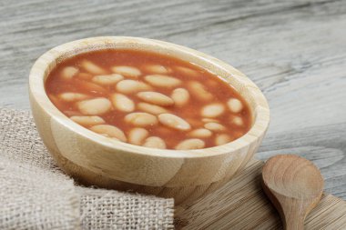 Pork and Beans 'in leziz öğle yemeğini kapatın. Fotokopi alanı olan ahşap bir arka planda.