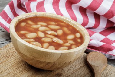 Pork and Beans 'in leziz öğle yemeğini kapatın. Fotokopi alanı olan ahşap bir arka planda.