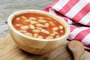 Pork and Beans 'in leziz öğle yemeğini kapatın. Fotokopi alanı olan ahşap bir arka planda.