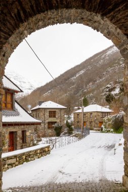 Karlı bir dağ köyündeki antik bir kilise inzivasının taş kemeri.