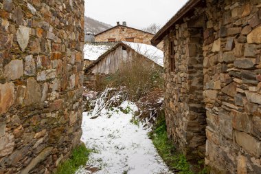 snowy stone streets and buildings in a picturesque town in the Spanish province of Len, called Colinas del Campo clipart