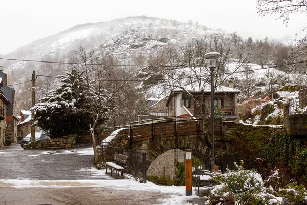 stock image a stone bridge over a river in a snowy mountain town