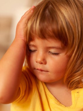 Baş ağrısı olan küçük bir kızın portresi.