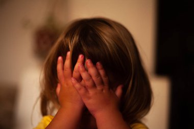 İki yaşında güzel bir sarışın kız gözlerini kapatıyor.