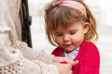 Kırmızı kazaklı gülümseyen kızın orta boy portresi.