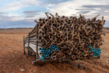 Açık alanda tarımsal sulama borularıyla dolu bir römork..
