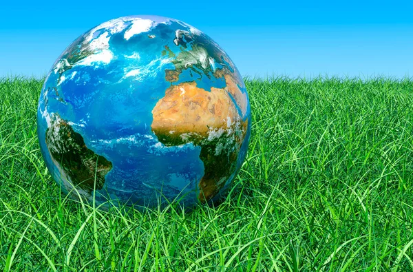 Earth Globe on the green grass against blue sky, 3D rendering