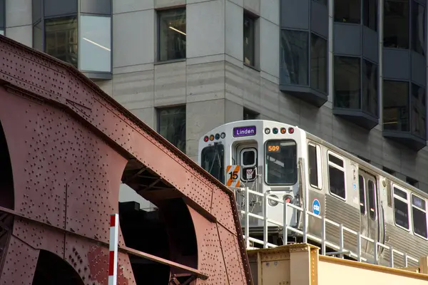 Chicago El Linton Treni gölgelerin arasından Chicago Nehri 'ni geçmek üzere.