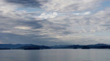  Alaska 'nın iç geçidi, Kraliçe Charlotte Sound' u, sabah ışığında, arka planda dağların güzel bir siluetiyle.