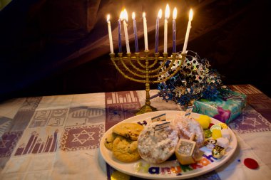 İsrail bayraklarıyla Hanuka 'nın sekizinci gecesi için aydınlatılmış bir menora. 