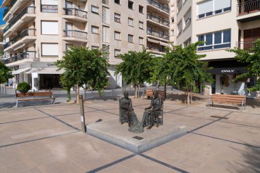 Hasır sandalyedeki kadınların yürüyüş heykeli 3 Ekim Pazartesi günü İspanya 'nın Cambrils Costa Dorada Tarragona Eyaleti' ndeki balıkçı ağlarını tamir ederken görülüyor.