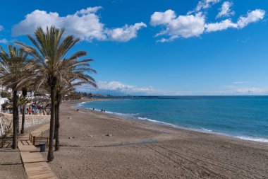 Playa de Santa Ana plajı ve palmiye ağaçları 24 Şubat 2023 Cuma günü Benalmadena, İspanya 'daki plajlardan Costa Del Sol' da