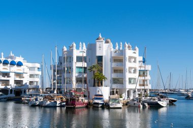 Benalmadena Marina, 2 Mart 2023 tarihinde İspanya 'nın Benalmadena şehrinde yelkenli tekneleri ve yatları ve güzel mavi gökyüzü ve deniz manzaralarıyla
