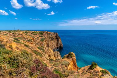 Lagos Portekiz kıyıları Ponta da Piedade ile Luz arasında altın uçurumlar ve mavi Atlantik Okyanusu arasında yürüyor.