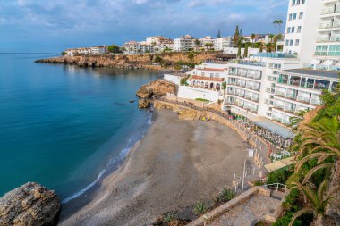 Chica beach Nerja Spain next to Balcon de Europa Costa del Sol Andalusia and blue sky and mediterranean sea and waves