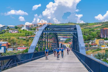 Bisikletçiler bisikletleriyle Ponte Pedonal Metalica brdge, Peso da Regua, Portekiz 'de 11 Mayıs Cumartesi günü yarışacaklar.