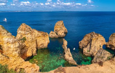 Ponta da Piedade Legos Portekiz 'in güzel Portekiz sahillerinde berrak deniz manzaralı körfezi geziyor.
